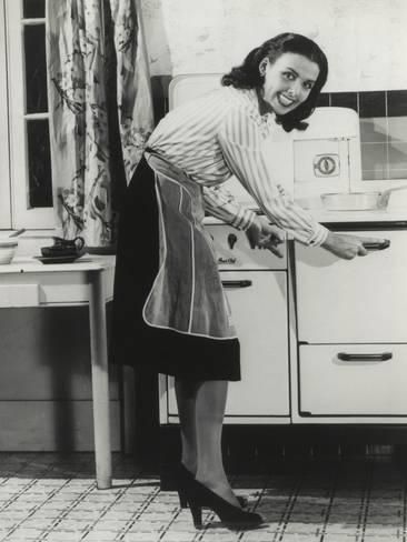 Actress Lena Horne at a gas stove in this 1940s photography. She was promoting fuel conservation during World War 2. 