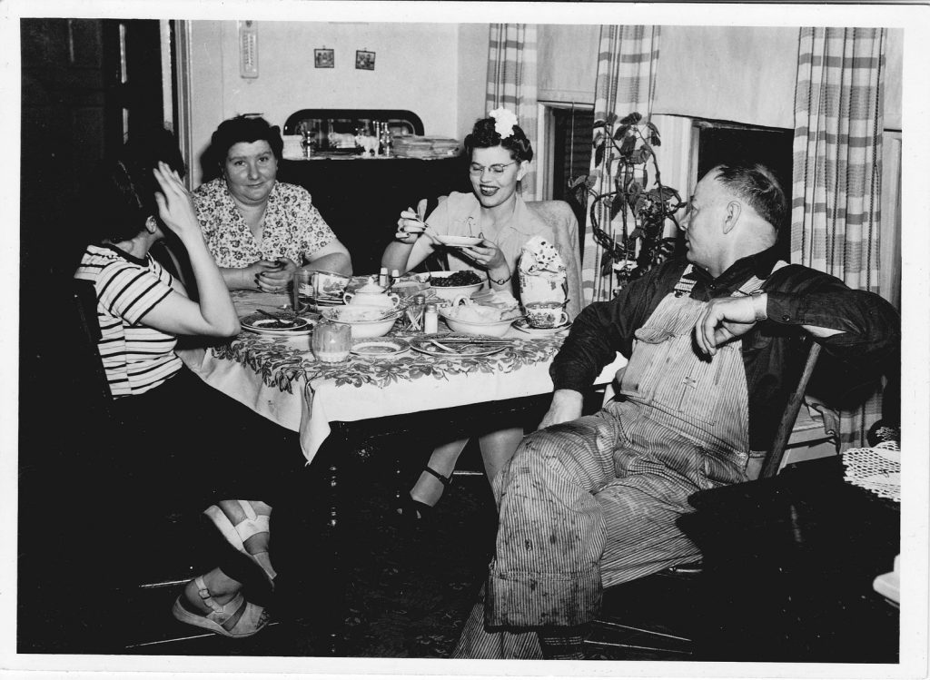 1940s vintage photo of a family enjoying dinner together. 