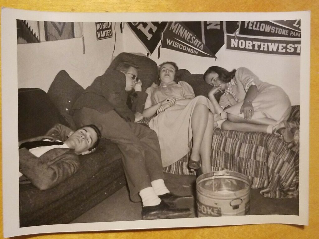 1940s vintage photo of college students sleeping at a party in 1940s fashions. 