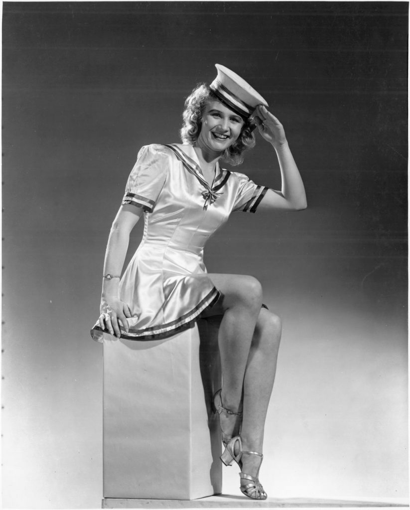 1940s Vintage Photo of a young woman from GECO Munitions factory in 1940s fashion. She is dressed a pinup sailor