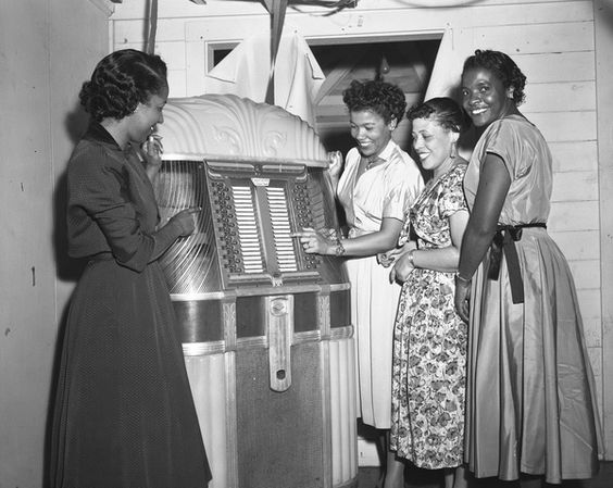 December 31, 1956, vintage photo of a group of Black Women at the jukebox during a New Year's Eve party in Tallahassee, Florida. 