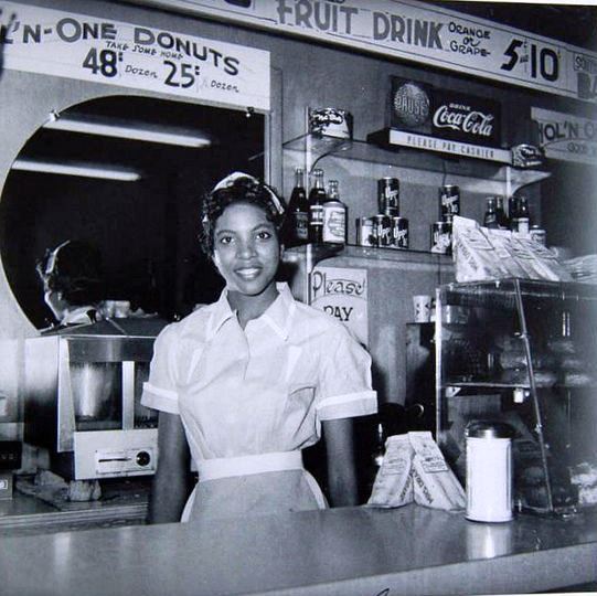 1950s 1960s vintage photo of a young black woman working at a coffee shop soda fountain