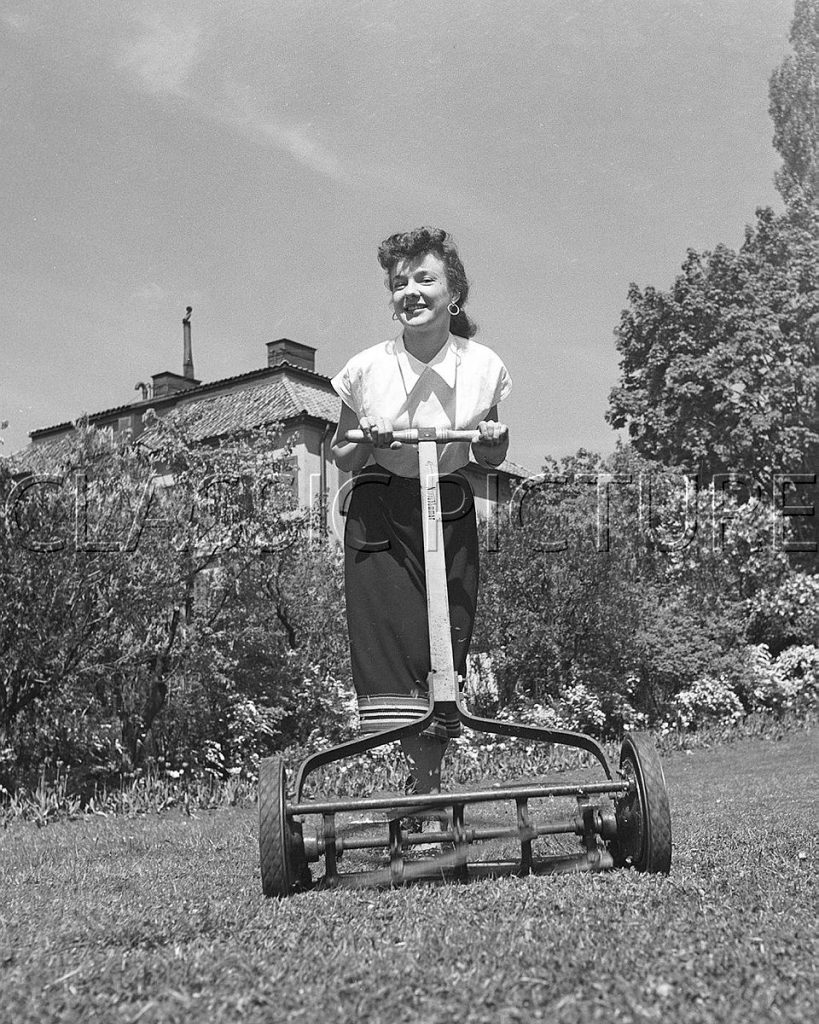 
Woman mows the grass with an ancient Norrahammar brand lawnmower. The Norrahammar brand and mill were bought by Husqvarna and then operated empty. 1980s. The picture from the 1940s