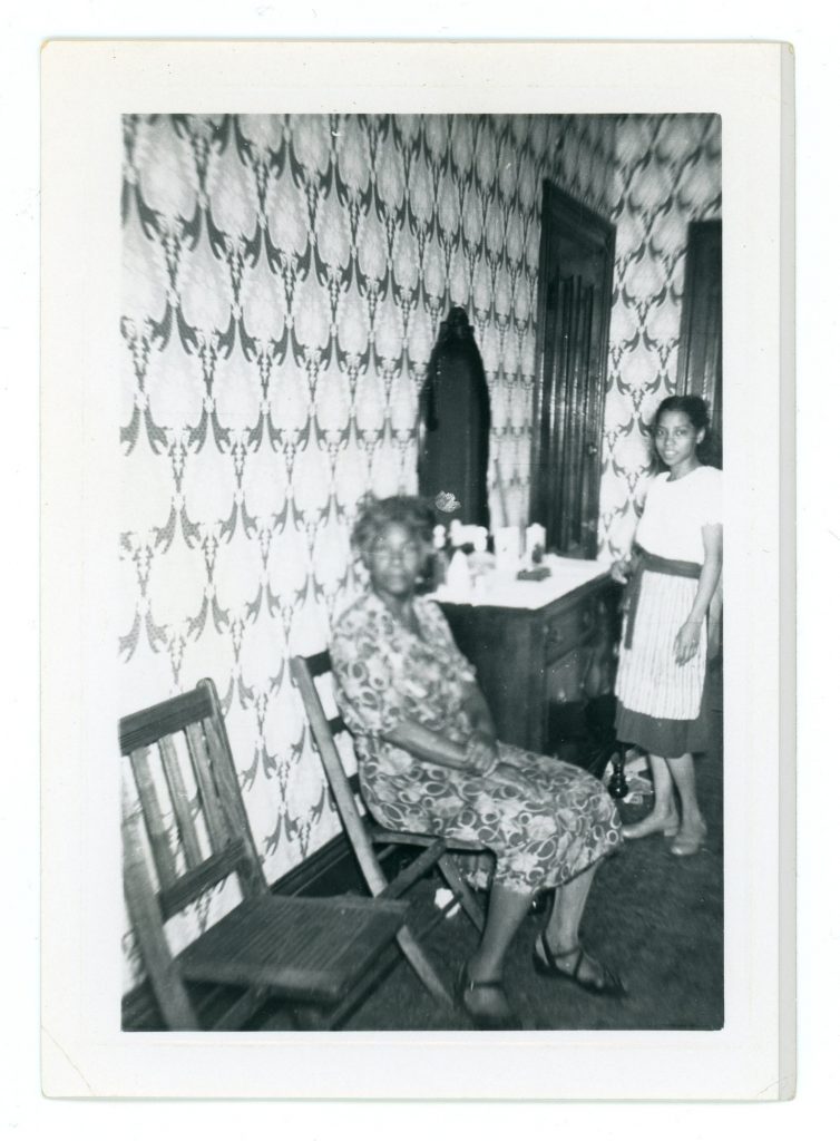 1940s 1950s vintage photo of a young Black woman and and older Black Woman in a room with fancy wallpaper