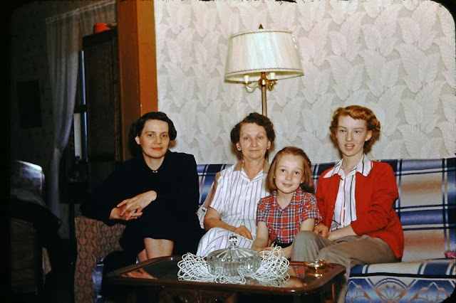 1950s vintage photo of a family in their 1950s living room sitting on a couch. Super 1950s hairstyles and 1950s fashions