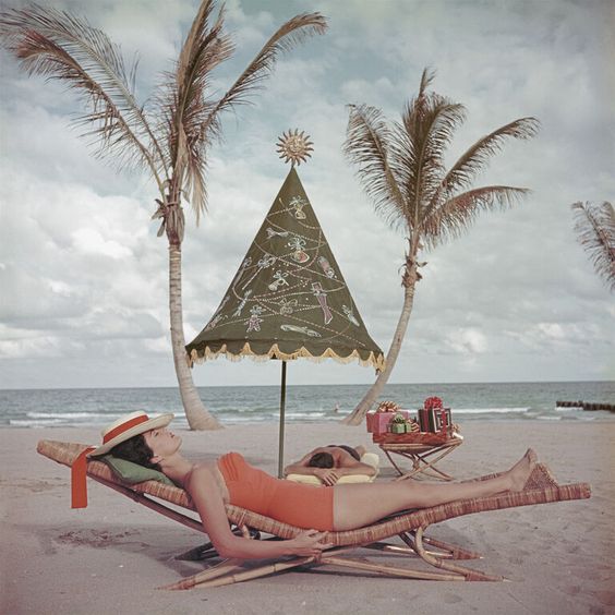 A couple sunbathing by the sea at Palm Beach, Florida, circa 1955 by Slim Aarons