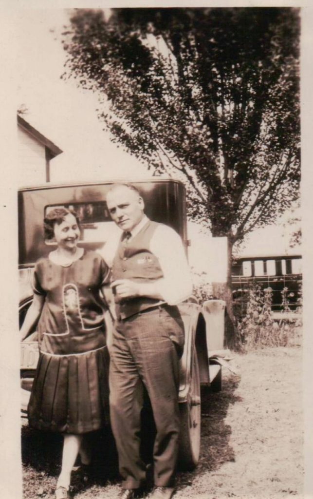 1920s Vintage Photo of a couple posing with their car in 1920s fashions. 