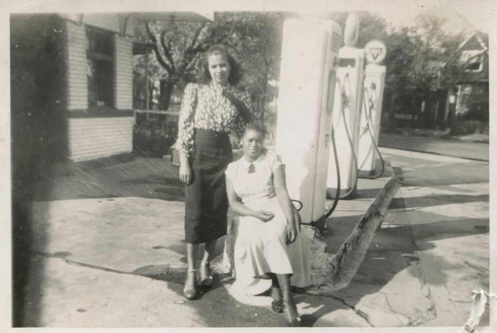 1940s vintage photo of 2 Black women posing together at a Gas Station in 1940s fashions