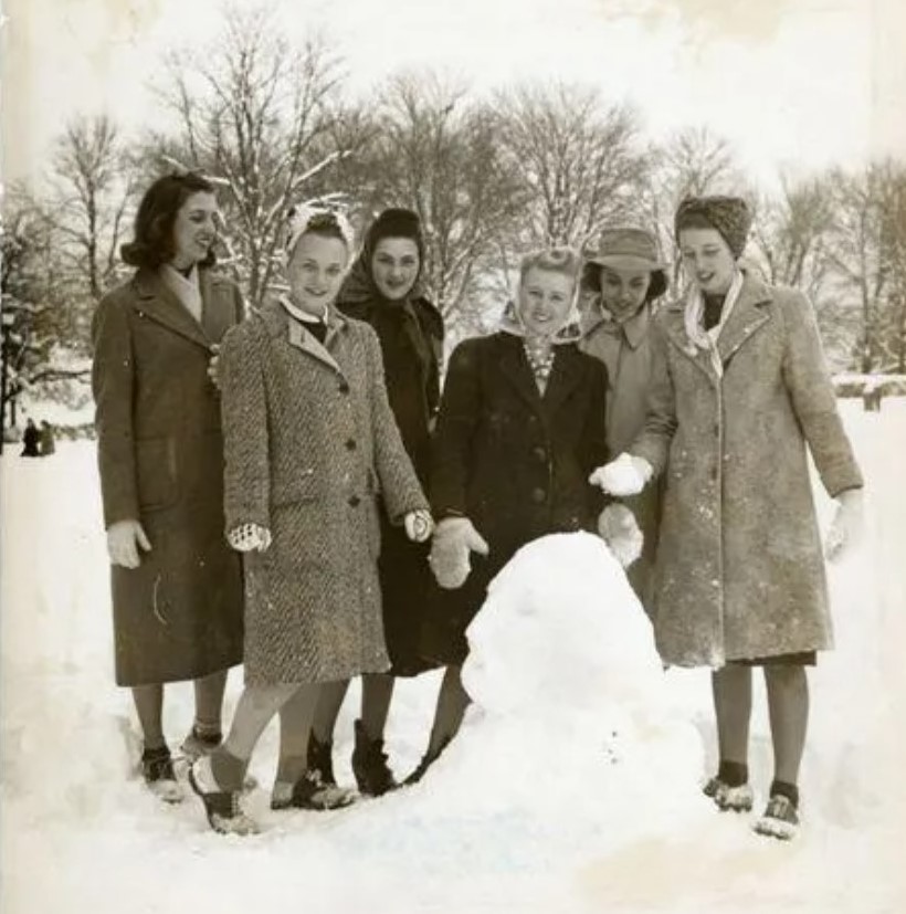 1940s vintage photo of young young women dressed in 1940s winter coats and 1940s hats and headscarfs in the winter