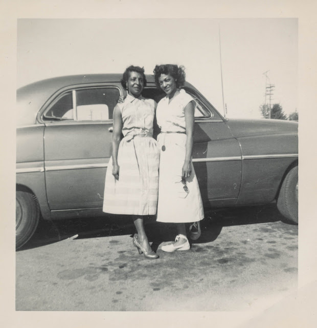 1950s vintage photo of 2 Black Women (mother & daughter) in 1950s Fashions posing together in front of their car. 