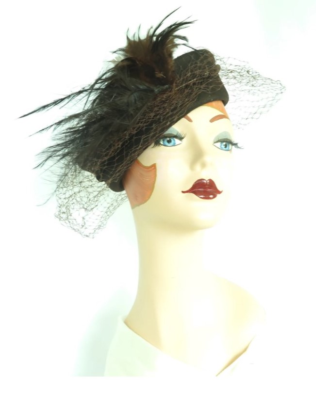 1940s vintage tilt hat. Woman's 1940s brown percher hat with dramatic feather accent off to the right.