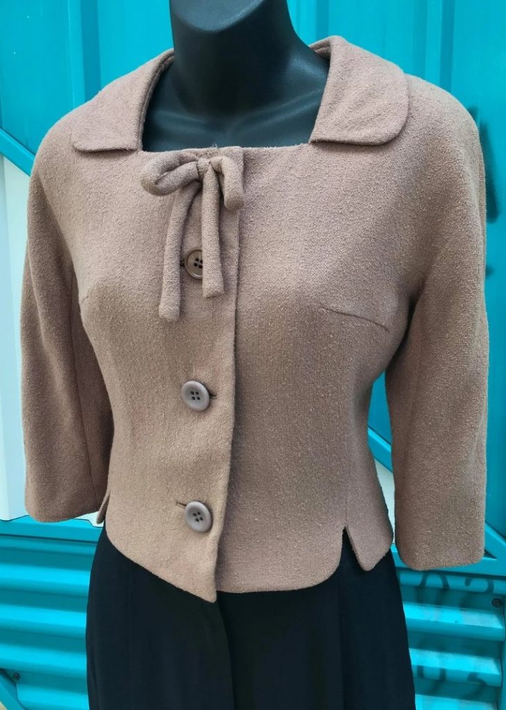 1940s Fashion: Vintage 1940s "Nathalie Nicoli" for "I. Magnin & Co" Wool Gabardine Cropped Jacket. Square neckline with collar, attached bow detail. Three buttons at front of garment. Fully lined.