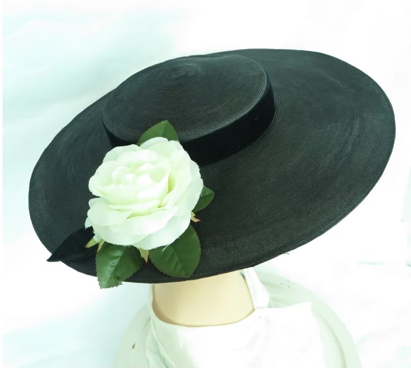 1950s black hat. Woman's wide brim ( 4 1/4 in.) platter hat accented with a perfect white rose. Shallow crown of the 50s ( or late 40s) black hat is encircled with black velvet ribbon which ties on the right.