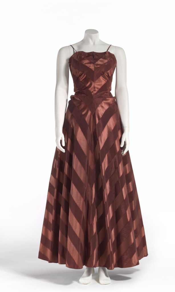 1950s Fashion: 1950 evening gown by LUCAS a bronze full length dress in striped moirè and satin acetate, cut on the bias. 