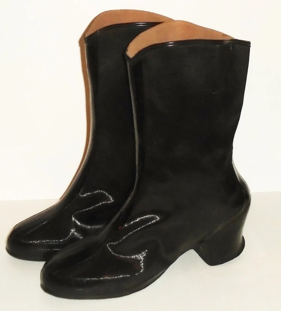 1950s Fashion: vintage overshoes from circa 50s. These black rain boots are two-tone glossy and matte rubber with cuban heels. They slip on and are just below mid-calf