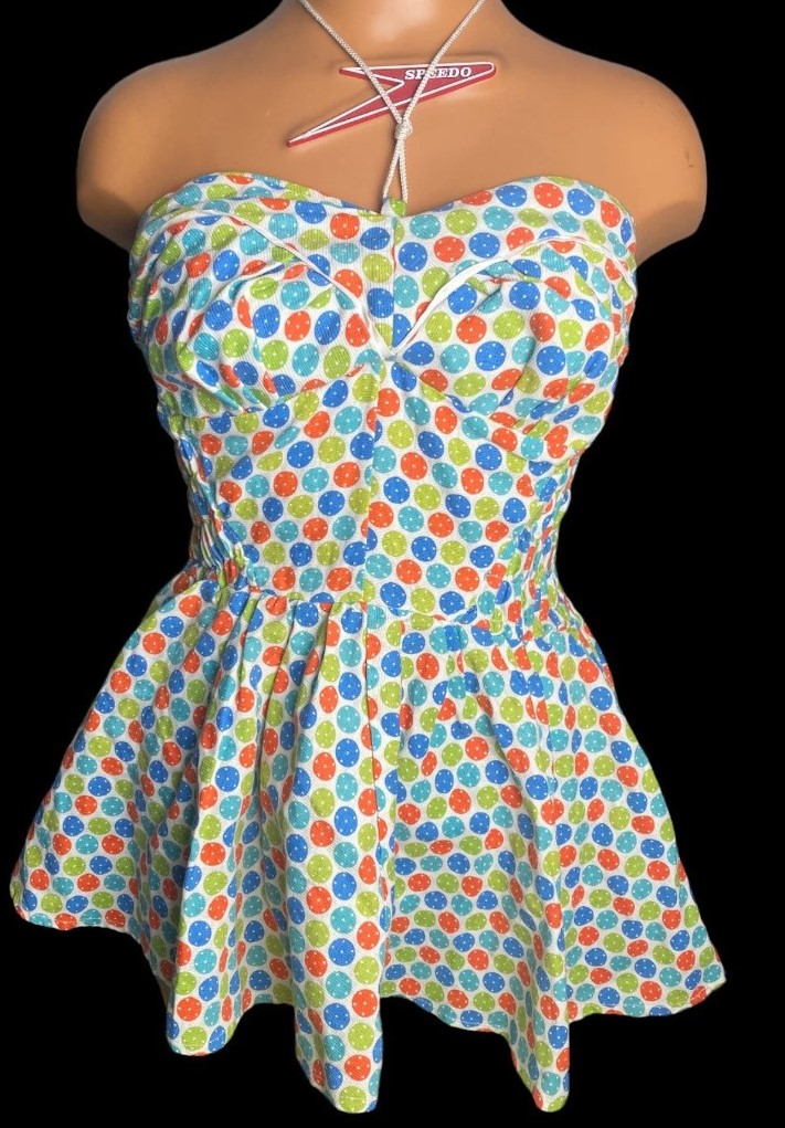 1950s vintage swimsuit with polka dots and a skirt. Fun 1950s fashion, maybe early 1960 fashion.