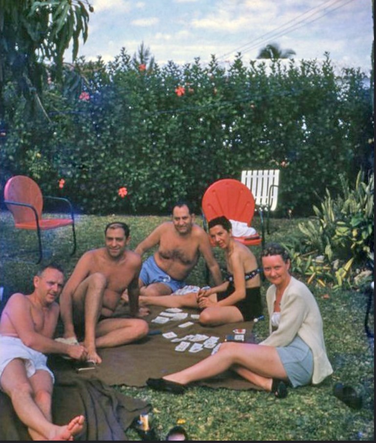 1950s vintage photo of People playing cards at a backyard party in Miami - 1955. Featuring 1950s patio furniture and 1950s summer fashion. 