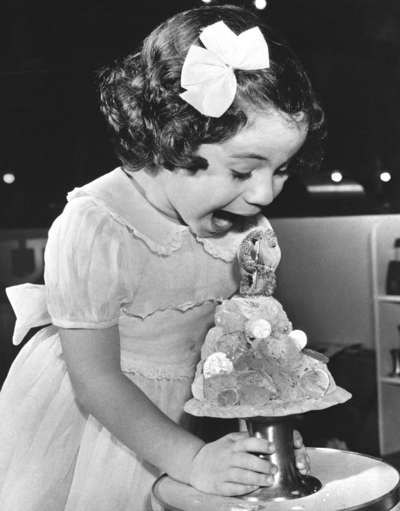 1950s Vintage Photo: A little girl in Atlantic City screams in amazement at her money-themed ice cream sundae.