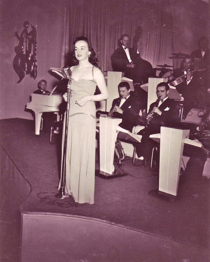 1940s Vintage photo of Canadian Veronica Foster performing with an orchestra in 1940s dress. 