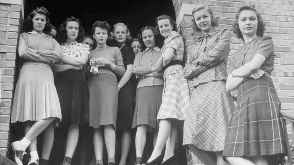 1940s vintage photo of a college women in a sorority in 1940s fashions including plaid fashions and saddle shoes. 