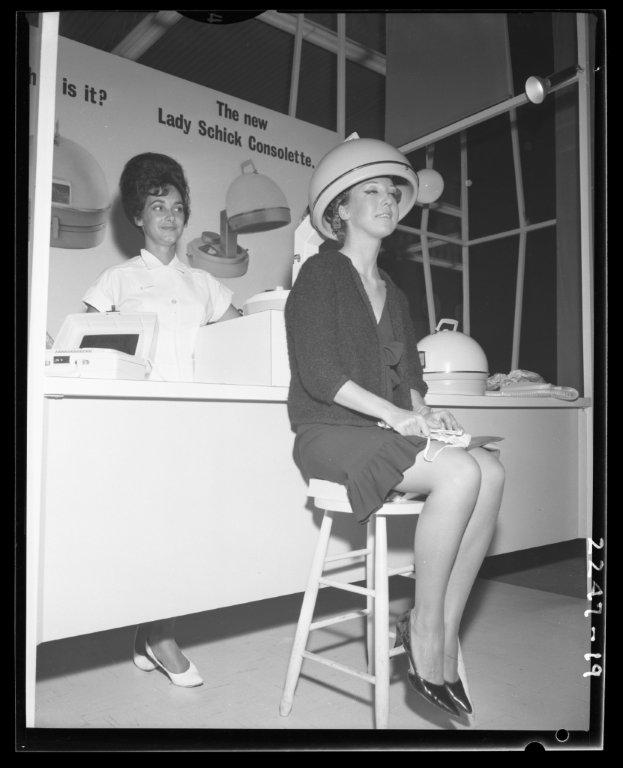 1960s vintage photo of a lady schick hair dryer demo at the Toronto CNE image features two women in 1960s fashions