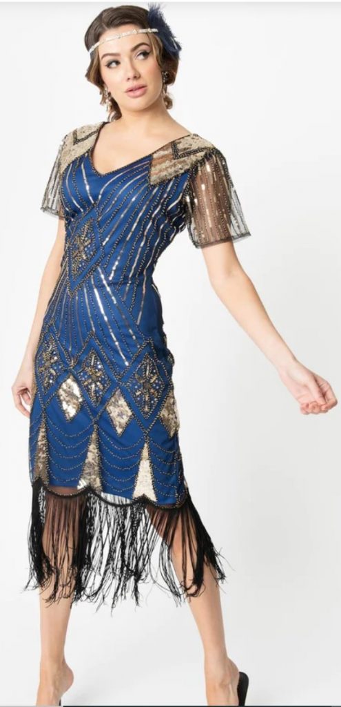 1920s Gold Sequin & Navy Fringe Flapper Dress by Unique Vintage. features a brilliant array of gold sequins and beading in a fabulous sunburst and chevron pattern throughout. The Katriane Flapper boasts a sultry V-neckline and sweet short sleeves in a delicate black mesh while the tapered waist flatters your figure. 1920s fashion. 