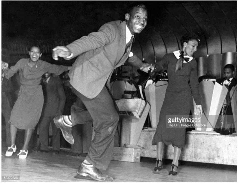 1930s vintage photo of Black Lindy Hoppers dancing at the Savoy Ballroom in 1930s fashions. 