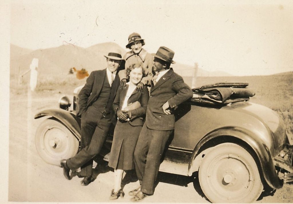 1930s vintage photo of men and women in 1930s fashions posing with a car