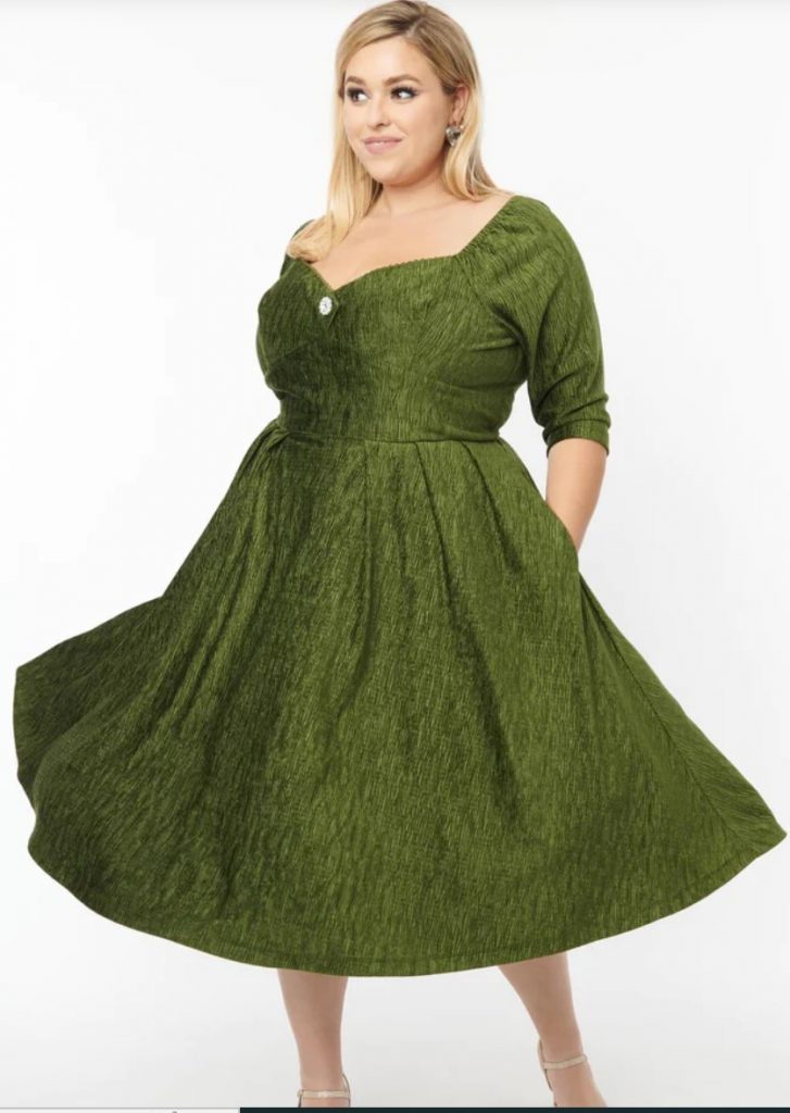 Unique Vintage 1950s Style Dress perfect for Holiday Parties. The Lamar Dress is cast in a beautiful green textured velvet. The stunning sweetheart neckline features a sparkling rhinestone faux button. Outfitted with a back zipper and side pockets.