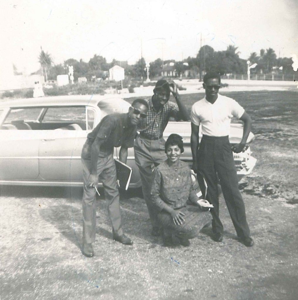 1960s vintage photo seen in a 1961 Yearbook of 4 Black students. Photograph of four students with caption "Miss Freshman of 59 & 60 pose with classmates". The Hornet (1961) page 30. Number 106 of 192 from archival box labeled Roosevelt Junior College Photographs. 