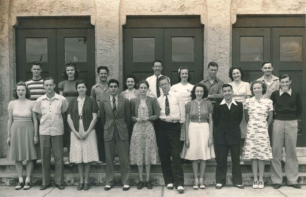 early 1940s vintage image of college students at Palm beach junior college posing together outside of their school in early 1940s fashions for women and men