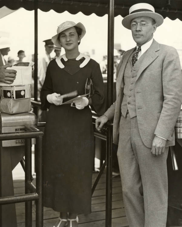 1930s Vintage Photo: Miss Kathryn Dougherty, 22, of Waterloo, Iowa, became the 2,000,000th visitor to the World's Fair when she passed through the 23rd street gate at 1:05 p.m. on Wednesday (June 20th). She is shown here with Martin M. Tveter, comptroller of the Fair, who presented her with the gifts seen at the left of the picture. 1930s Fashion's on display. 