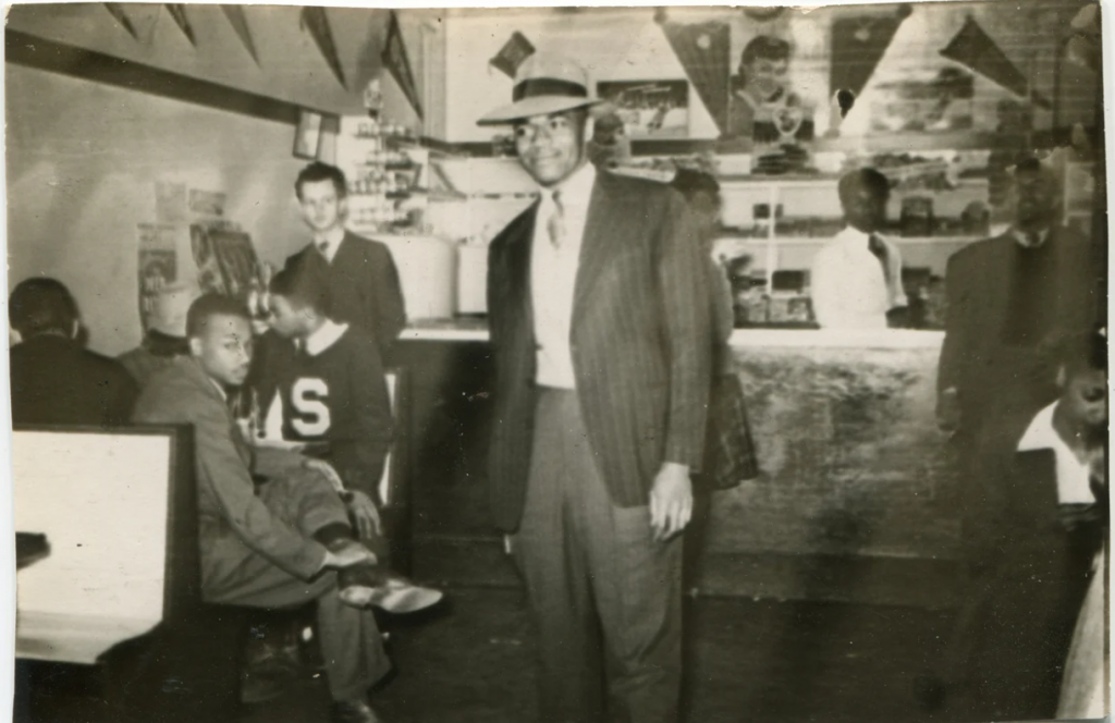 1940s vintage photo of a group of Black men and woman enjoying their college bar. Fun 1940s college fashions. 