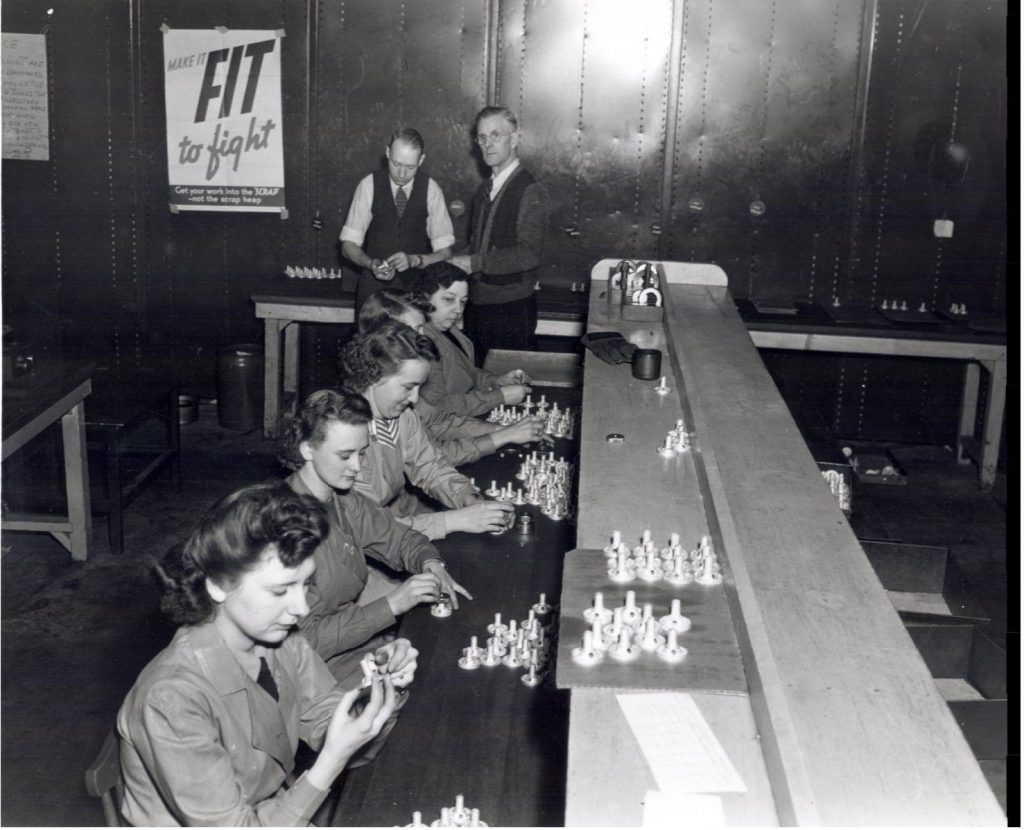 1940s vintage photo of parts of a smoke bomb being inspected at a factory in Waterloo, ontario canada during WW2. 