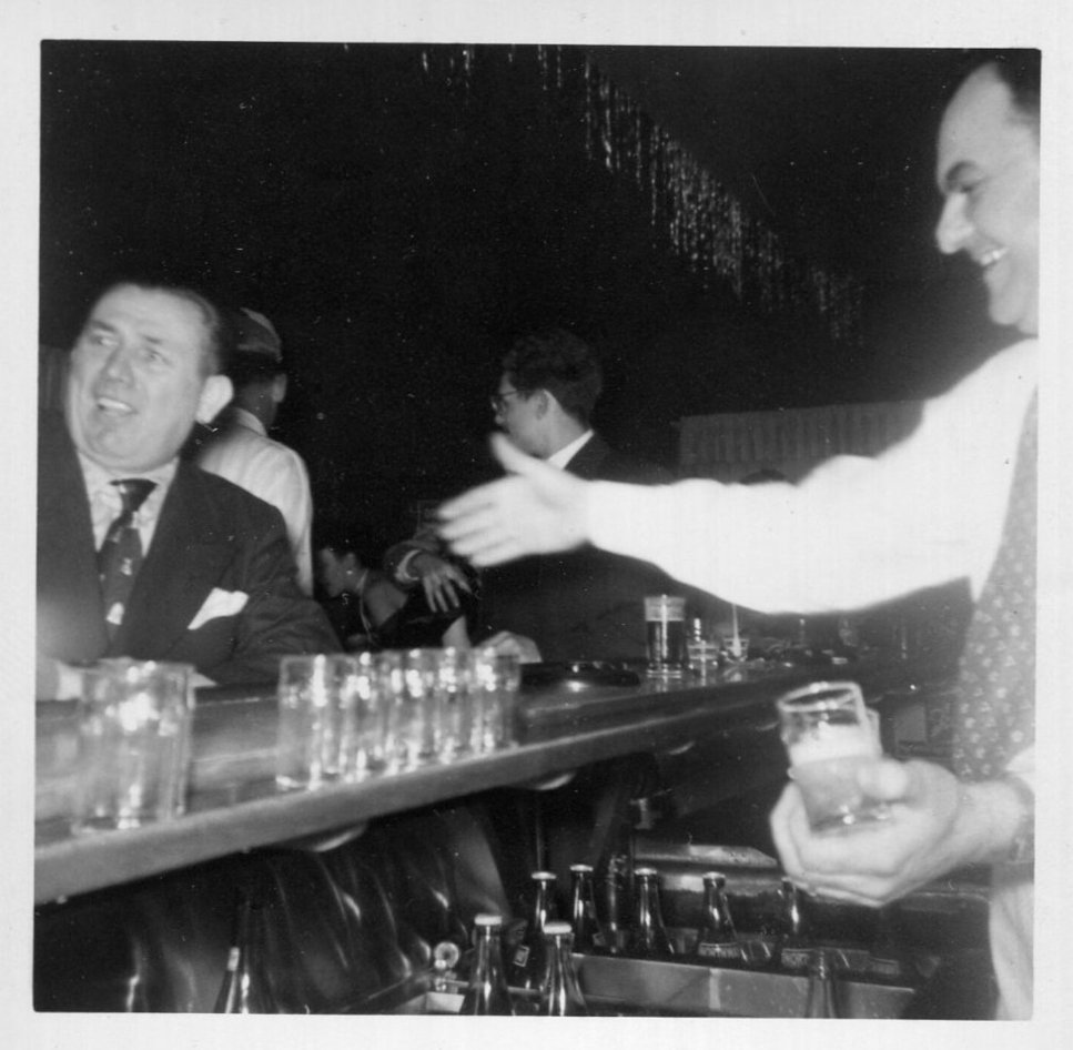 1950s vintage photo of people at a bar and a bartender making drinks