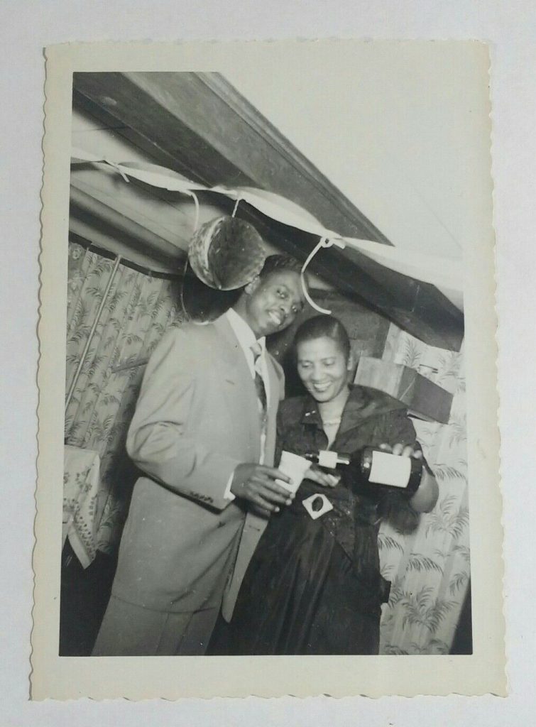 1950s Vintage Photo of a Black Man and Black Woman enjoying a drink at a New Years Eve Party