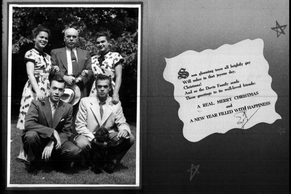 1950s vintage Christmas card featuring a photo of a 1950s family (the woman are wearing matching 1950s dresses) and a holiday greeting on the other side. 