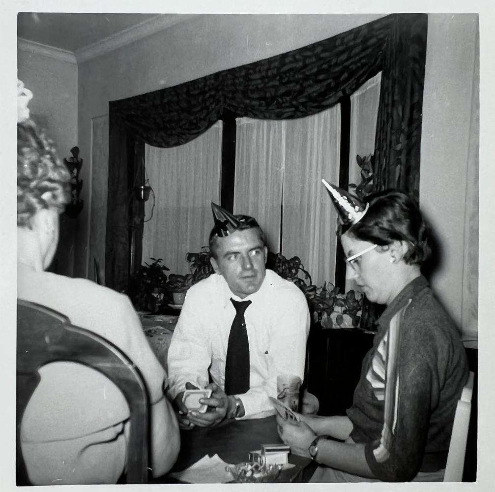 1950s vintage photo of people on New Years Eve wearing funny hats playing card games