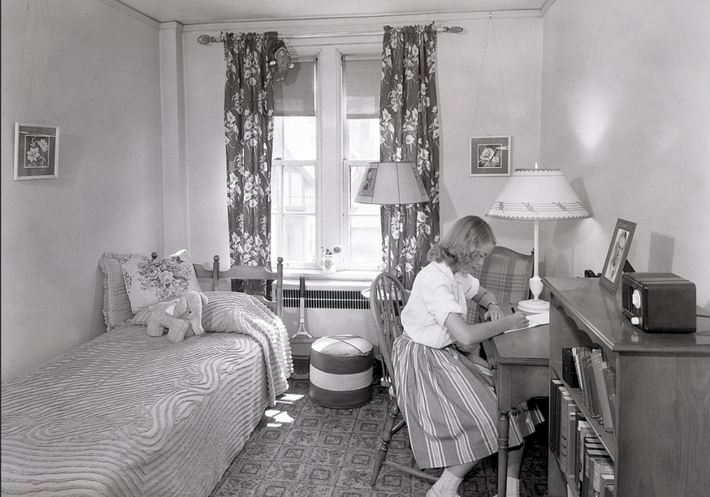 1940s vintage photo: 1941 photo of a a girl in her College dorm room in Wisconsin in 1940s fashions