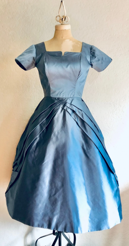 1950s Fashion: 1950s fit and flare shape satin gown in a dusty blue by Ceil Chapman