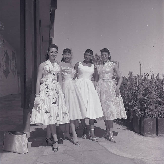 1950s photo of four showgirls in 1950s dresses outside the Moulin Rouge, preparing for the Helldorado parade, dated May 5, 1955.