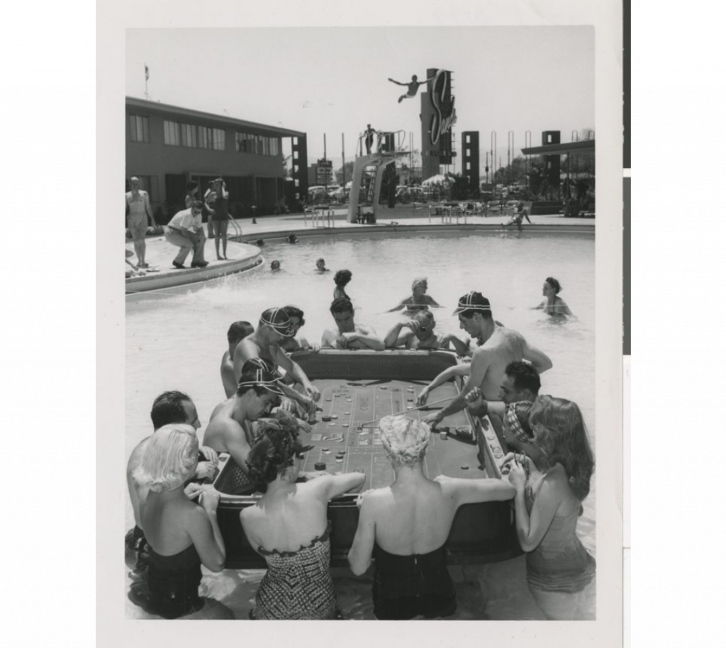 1950s vintage Photograph of a floating craps game in the Sands Hotel swimming pool (Las Vegas), 1954. Cute 1950s swimsuits on the women. 