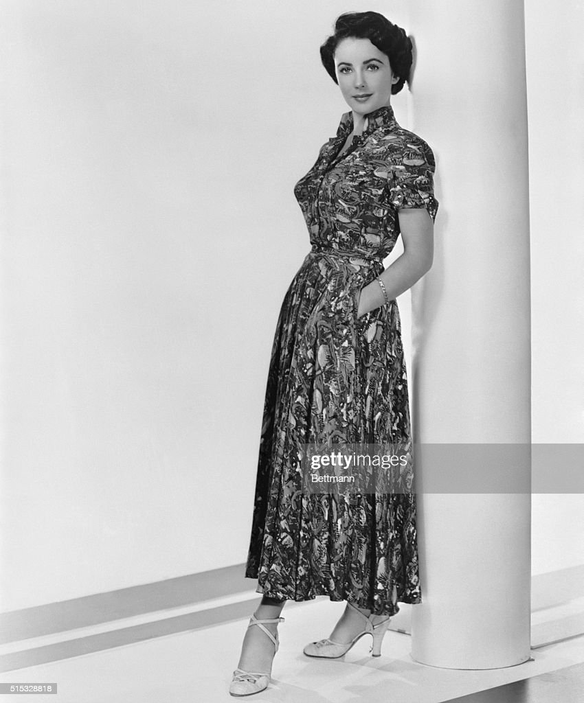 Late 1940s Fashion-1949 Hollywood, CA- Vivid green, coral blue and yellow are combined in the tropical print frock by Ceil Chapman, designed for actress Elizabeth Taylor's own wardrobe. The colorful afternoon dress features a deep plunging neckline and a pert stand-up collar. The full skirt, with deep pockets hidden in its folds, is topped by a fitted, short-sleeved bodice and a self belt.