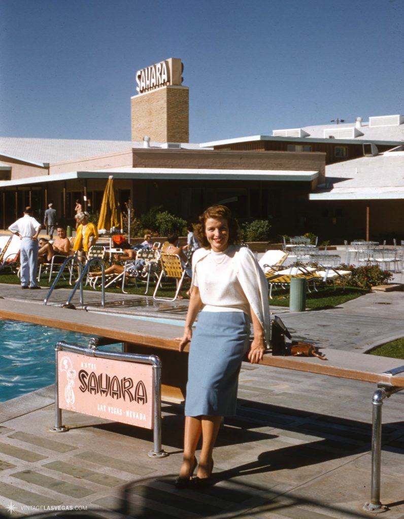 1950s vintage photo of a stylish woman in 1950s fashions and 1950s hairstyle hanging out At the Sahara hotel pool, early 1950s. (Undated Kodachrome red border slide.)