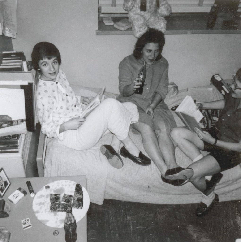 1960s vintage photo of three young women at the University of Wisconsin Madison in 1960s fashions eating pizza and drinking sodas in their dorm. -Vintage Dorm Life. 