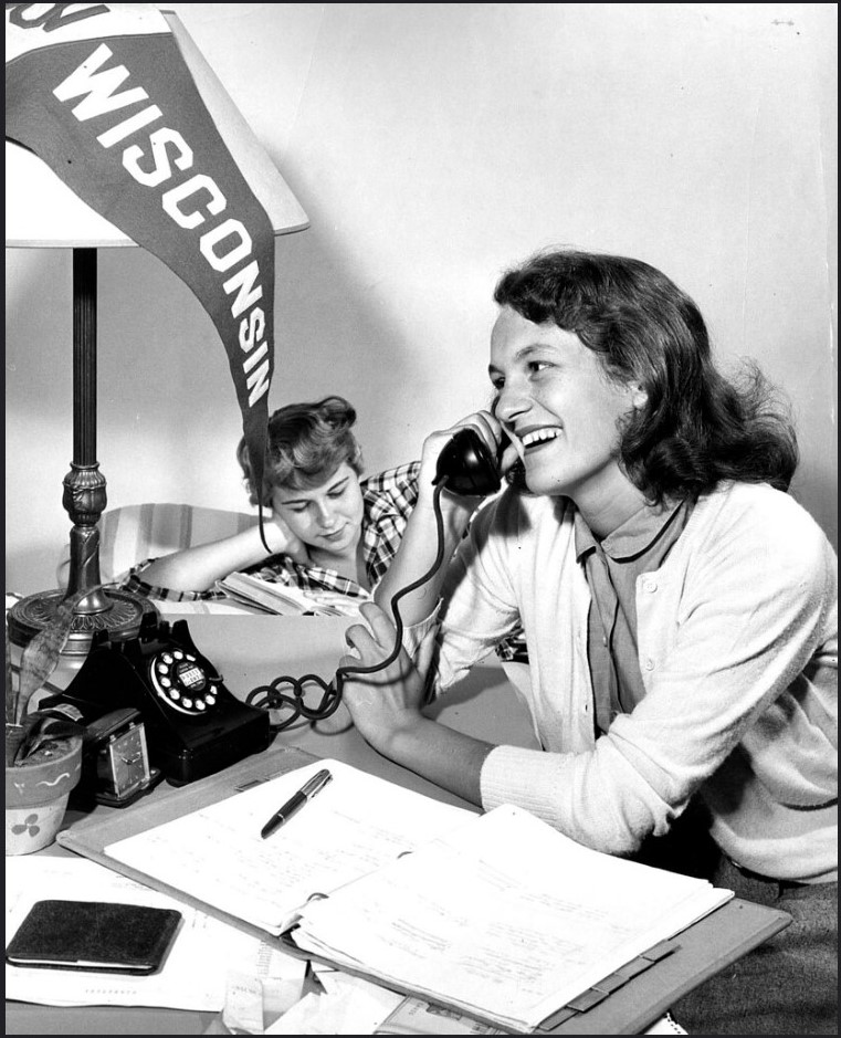 Vintage photo maybe 1950s or 1960s of two women hanging out in their dorm room studying and on the phone at the University of Wisconsin Madison