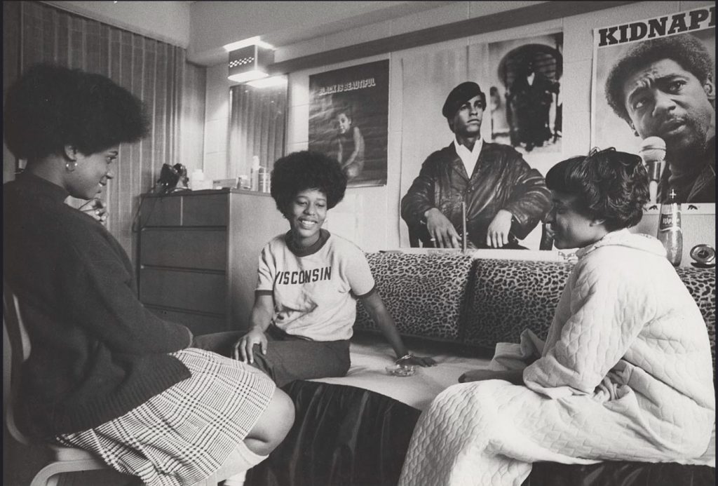 vintage photo from the 1960s or 1970s of Black women in a dorm room at the University of Wisconsin Madison surrounded by Black Activists