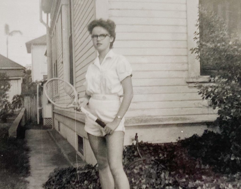 1950s vintage photo of young woman in shorts and blouse holding a tennis racket -1956.  1950s tennis outfit inspiration 