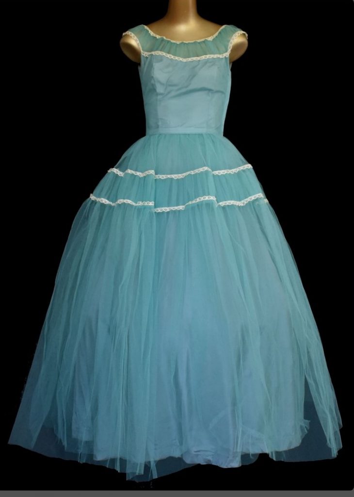 1950s Fashion: Gorgeous blue tulle evening gown trimmed with white lace by Emma Domb California. Circa 1950s. Classic 50s New Look dress with a fitted bodice, nipped waist and full gathered flaring skirt.