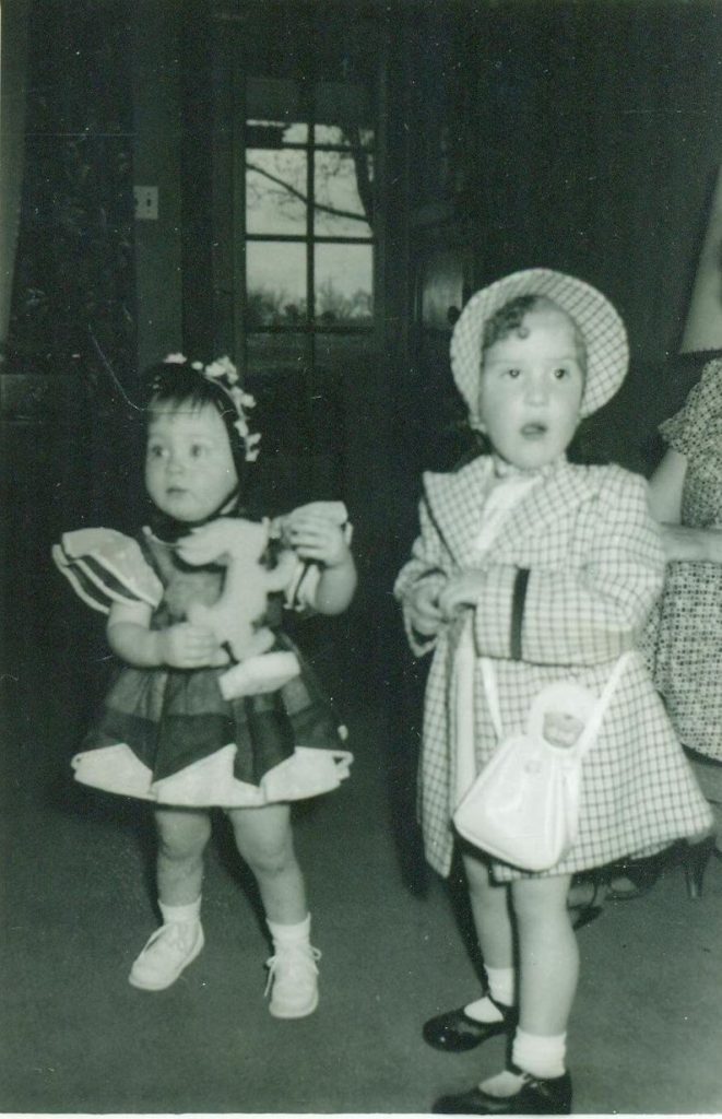 1950s vintage photo of two little girls in their Easter dresses and easter hats 